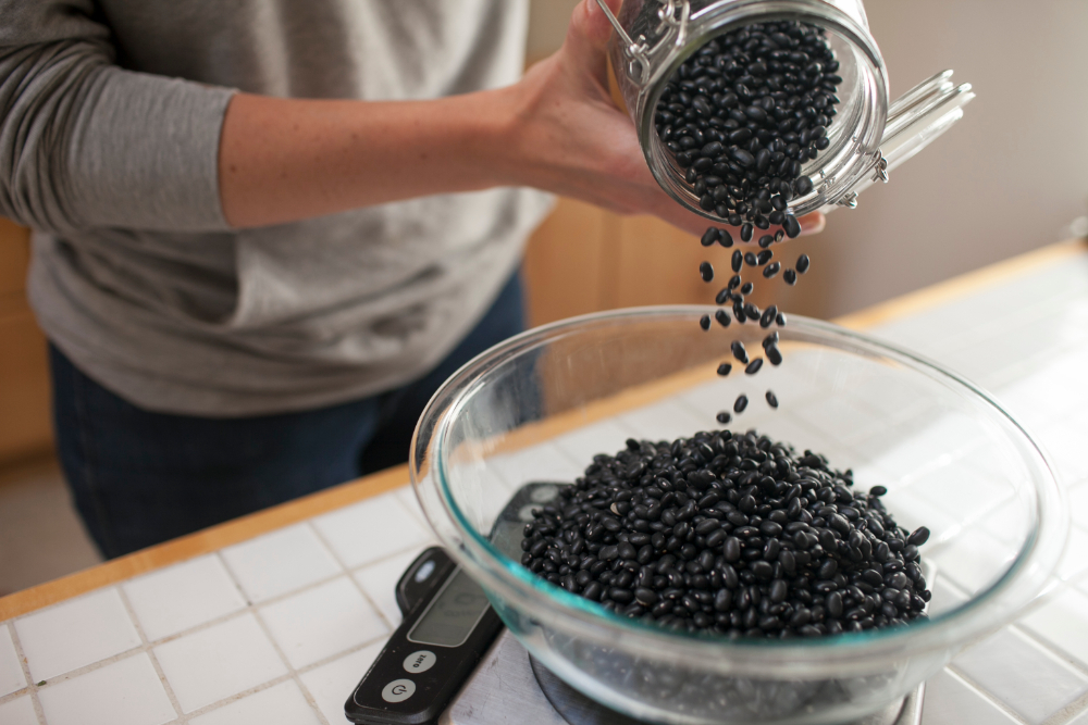 pouring dry beans into bowl on a scale from scoop marketplace zero waste grocery seattle