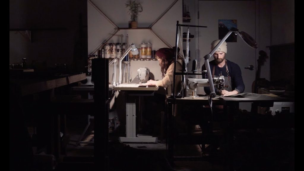 two people sewing and working on leather products at uphill designs in seattle